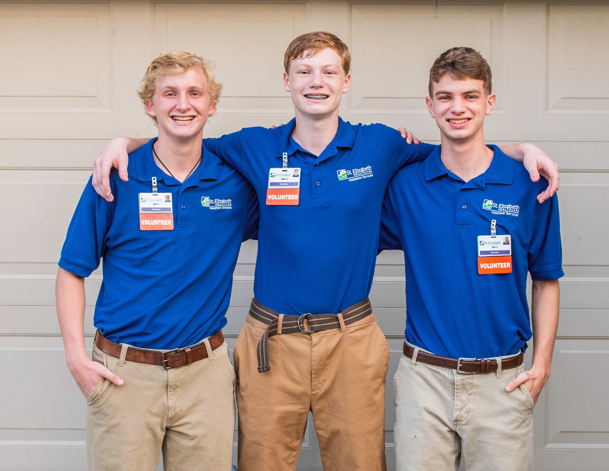 Three High School Boys pose for a photo with blue polo shirts with St. Elizabeth Healthcare logo