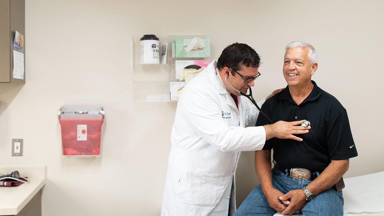 Dr. George Christenson listens to the heart of a patient.