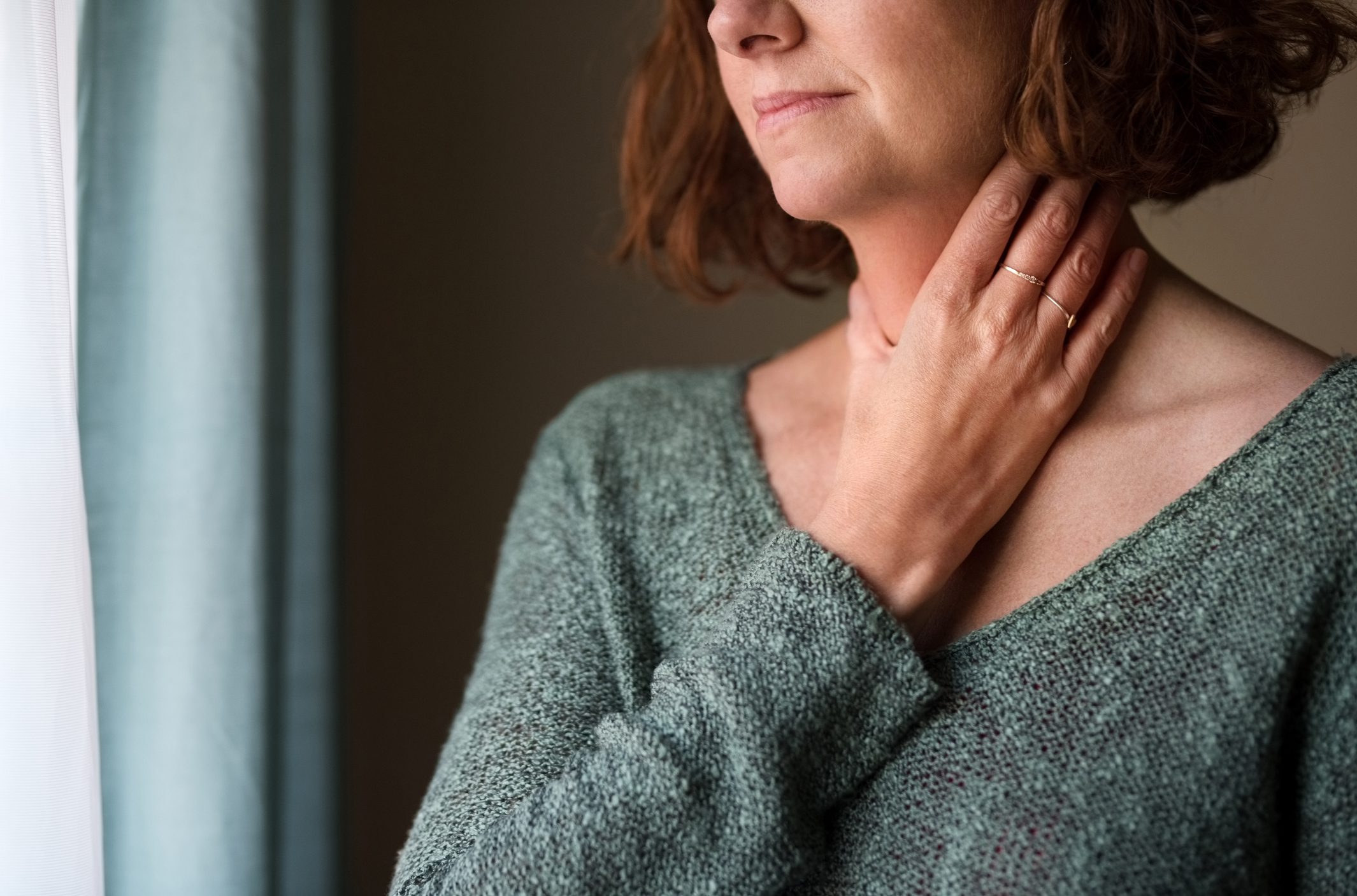 Neck and Head Pain Woman holds her painful throat