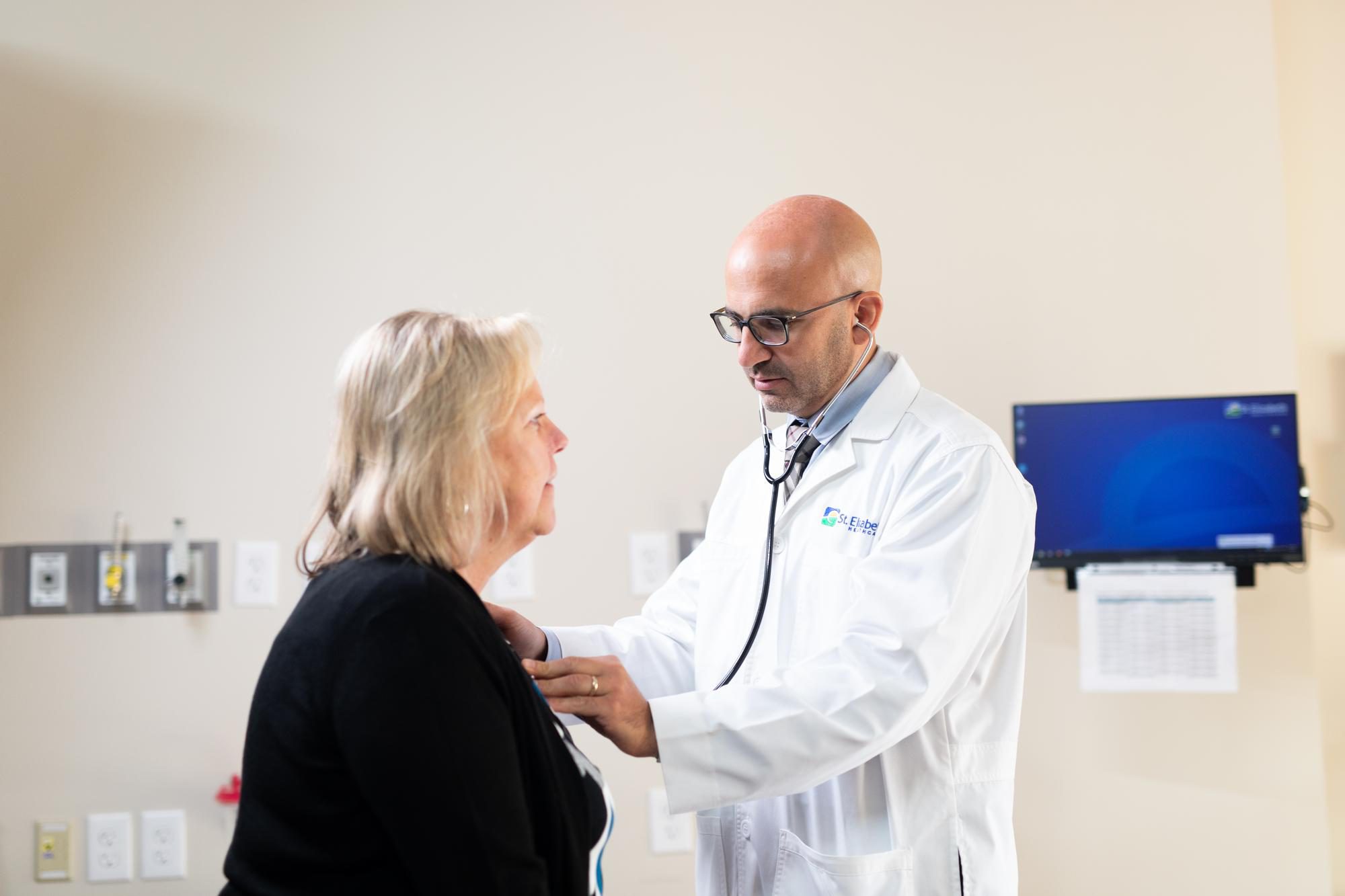 Dr. Sinno checks the heart of a patient.