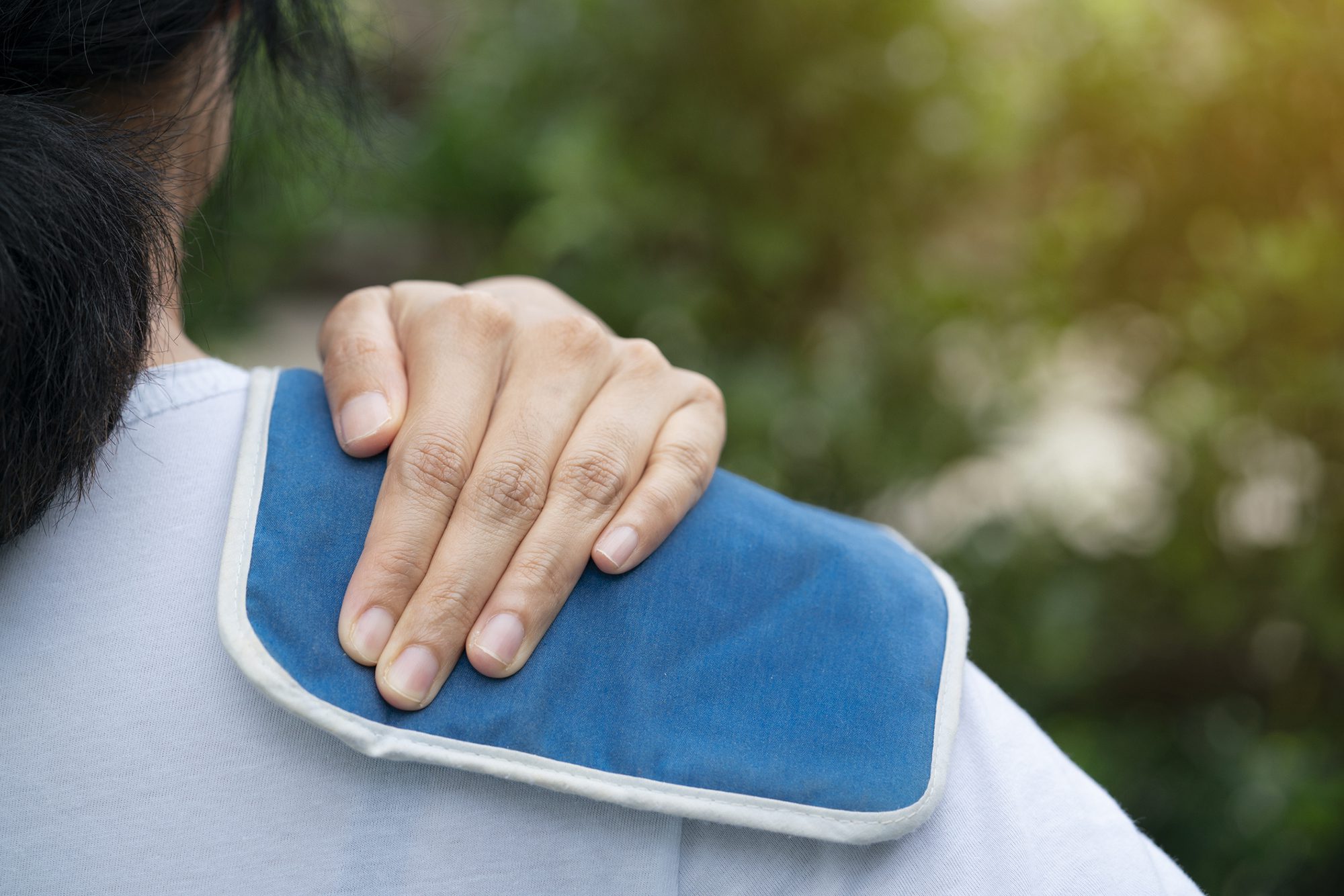 woman putting an ice pack on her shoulder pain