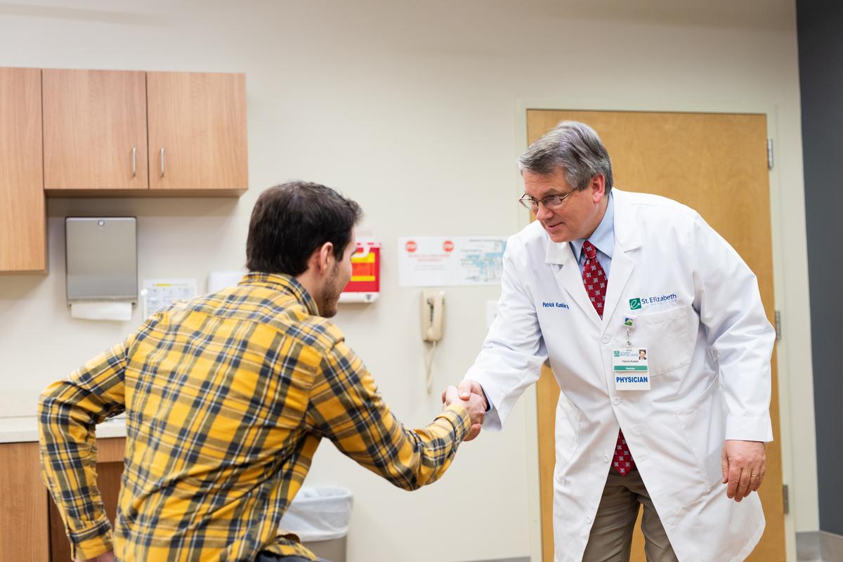 Dr. Patrick Kunkler shakes the hand of a patient.