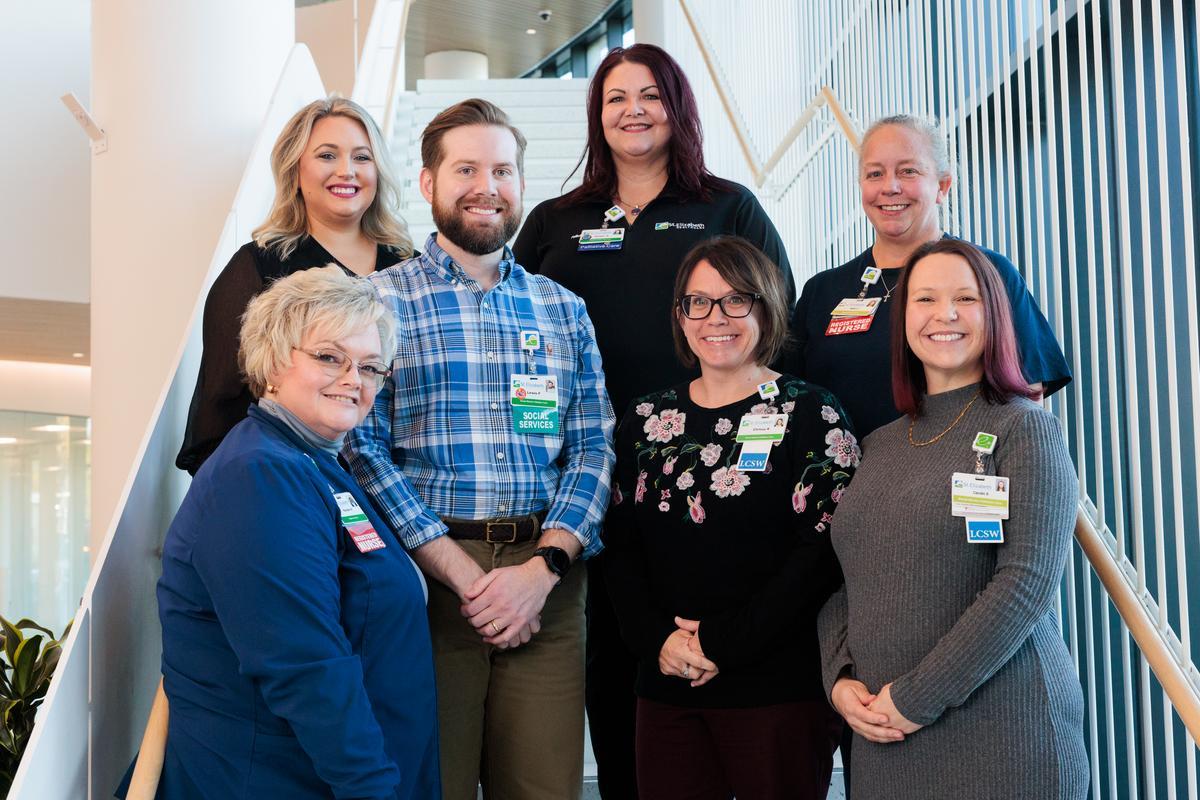 STE-PALLIATIVECARE-11 A group of healthcare workers pose of a group photo in front of a stairwell.