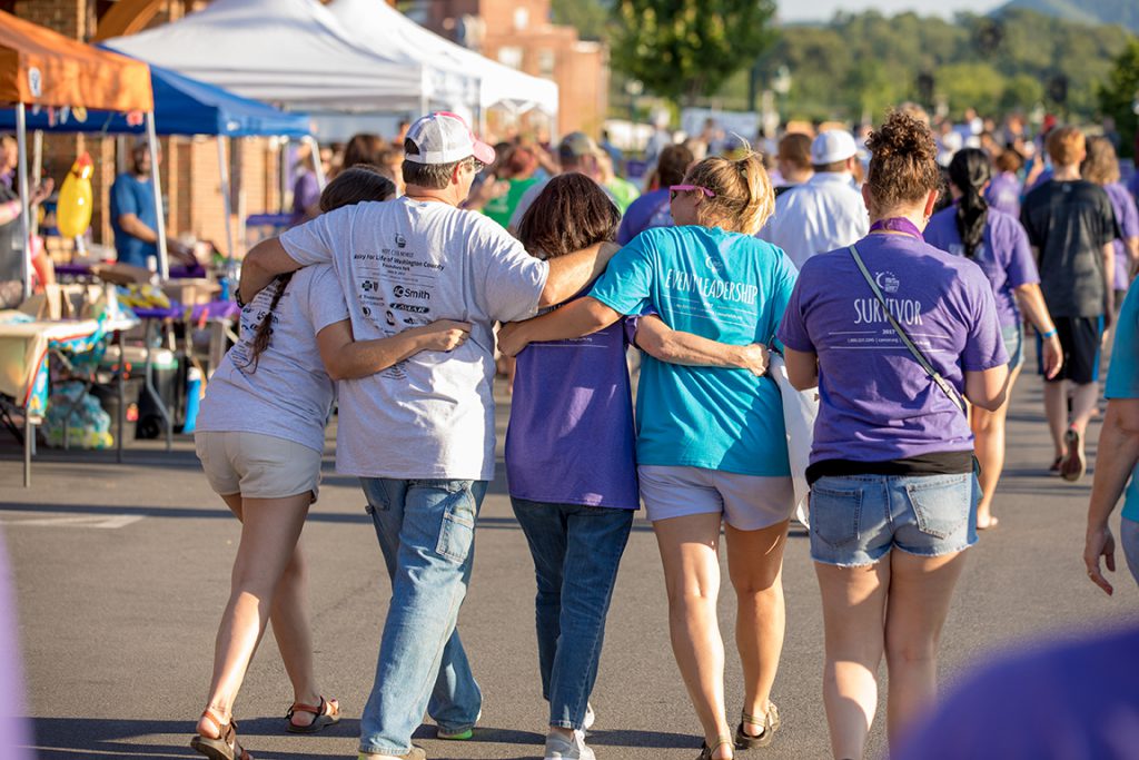 Relay for Life participants walk arm in arm