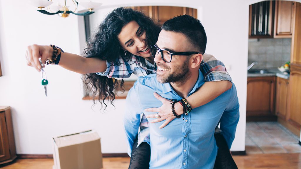 Young couple holding the keys for their new home.