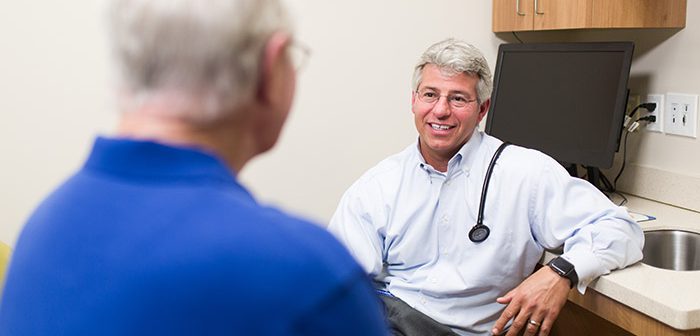 Dr. Jeffrey Reichard meeting with male patient.