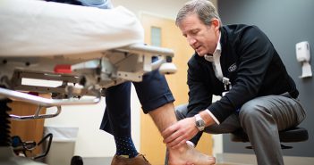 Dr. Gates looking at a patient's ankle.