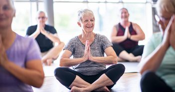 A group of seniors are sitting crosslegged and meditating in a fitness center. 1053396360 Example of service planned to be available in the doTERRA Center for Integrative Oncology