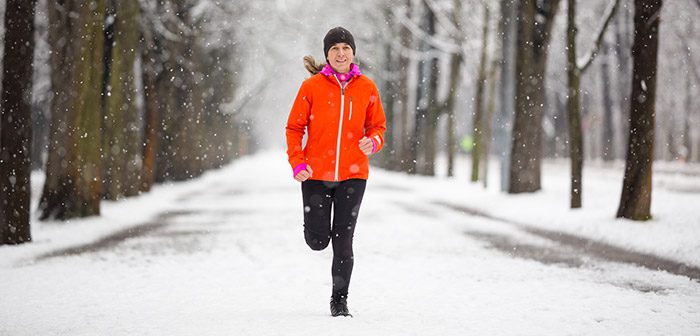 Women running in snow with proper weather protective gear.