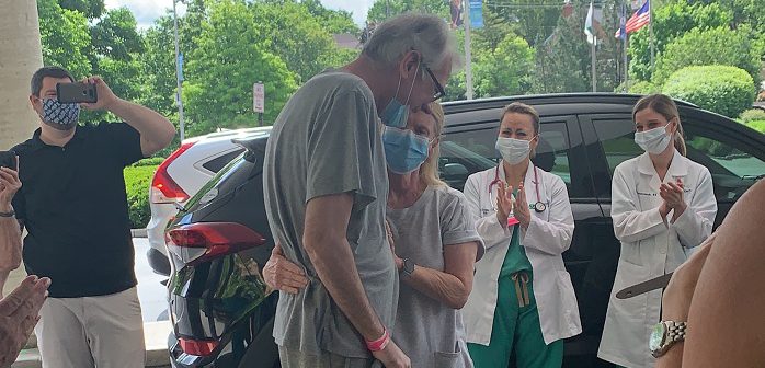 Scott Bona, COVID-19 patient leaving hospital for first time, hugging family.
