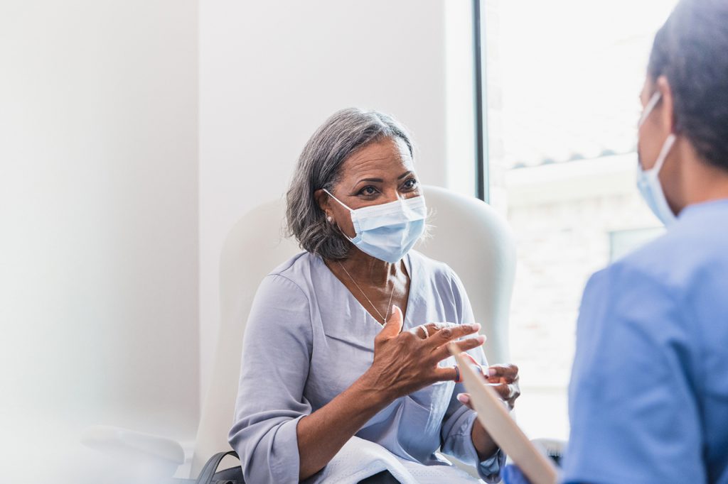 Senior adult patient talks with doctor.