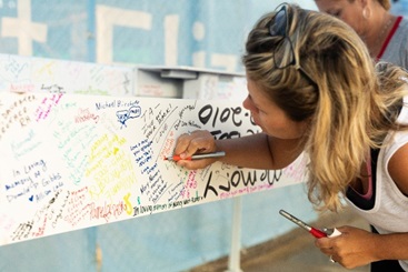 A woman signs the steel beam of the new Edgewood Cancer Center in 2019