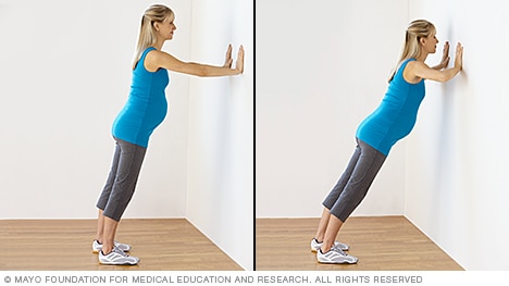 Pregnant person doing a wall pushup