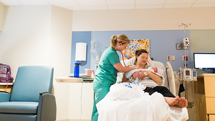 Lactation consultant with new mom and baby in family birth place